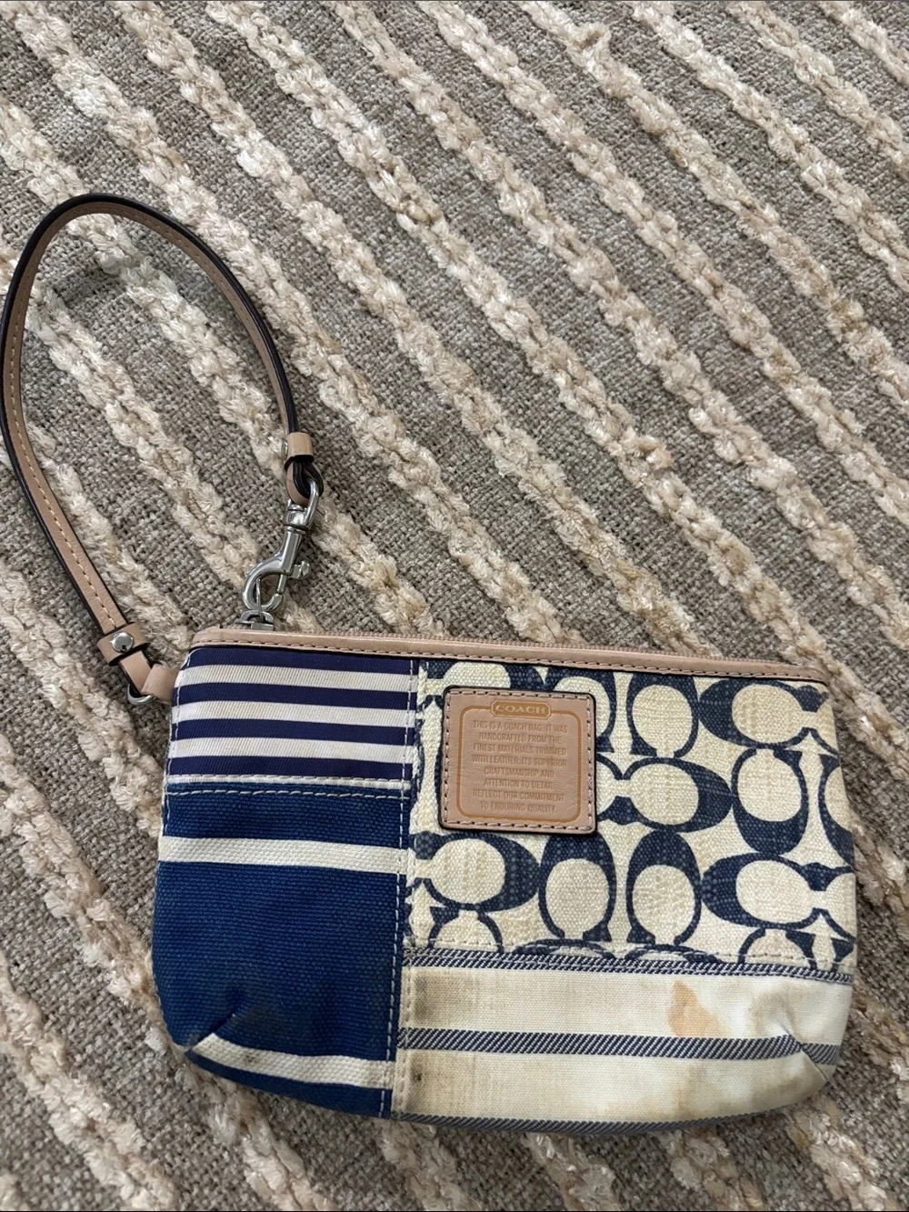 Coach wristlet featuring signature patchwork print in navy and cream